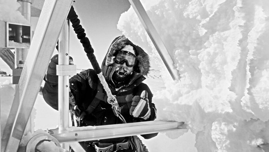 black and white image of man on tower in the winter