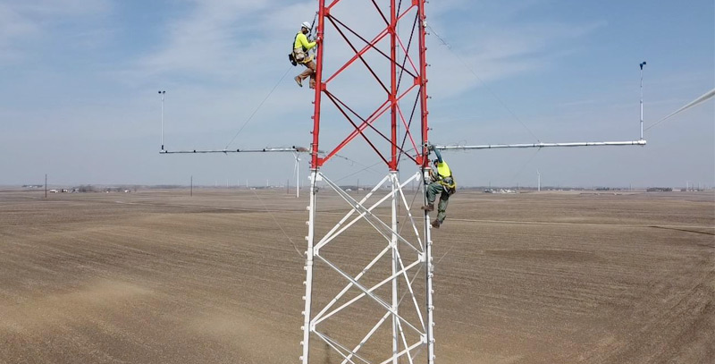 two men working on a MET tower